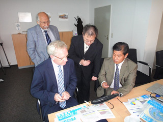 ｉＰａｄでグリーン･エコプロジェクトについて説明する遠藤環境部長（右）