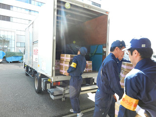 備蓄倉庫から救援物資を積み込む輸送隊員